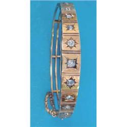 A late Victorian gold hinged bangle, the graduated front gypsy set with 11 old brilliant cut diam...