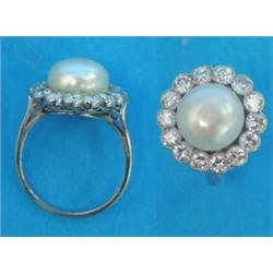 A white gold, pearl and diamond circular cluster ring, the bouton cultured pearl bordered by 14 m...