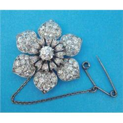 An Edwardian white gold all diamond flowerhead brooch, the central old brilliant cut diamond surr...