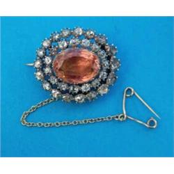 A Victorian oval brooch, set with a central foil backed topaz in a 2-row border of rose cut diamo...