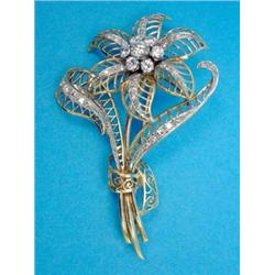 A modern gold openwork floral spray brooch, set brilliant cut diamonds...