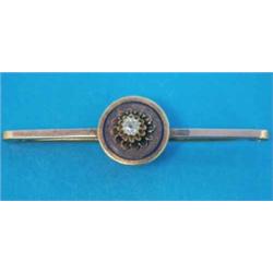 A gold tie pin, set with a single diamond in a circular gold and enamel mount...