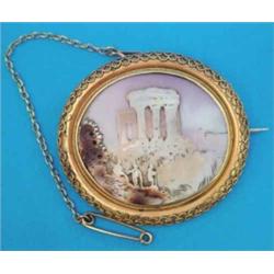 A Victorian shell cameo oval brooch, carved with figures standing before classical ruins, in wire...