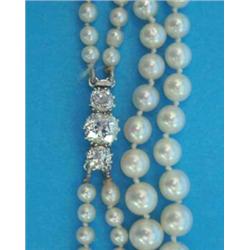 A 2-row graduated cultured pearl necklace, the white gold clasp claw-set with 3 old brilliant cut...