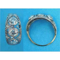 A gold ring, collet set with 3 old brilliant cut diamonds in an open work bezel set small diamond...