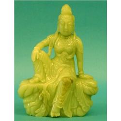 CELADON NEPHRITE JADE FIGURE OF GUANYIN, Chinese. Carved seated on a rock dressed in a loose ro...