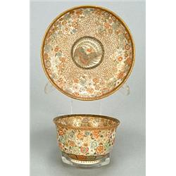 A Japanese pottery teabowl and saucer, finely decorated with a phoenix medalion and scattered but...