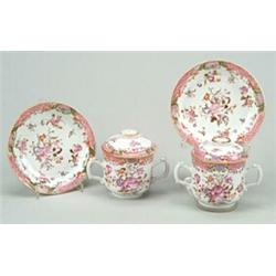 A set of five Chinese famille-rose two handled cups, covers and stands, each with sprays of flowe...