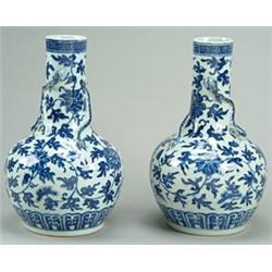 A pair of Chinese bottle vases, the slender necks applied with slender dragons and decorated over...