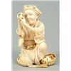 Image 1 : A Japanese ivory figure of an egg seller, the crouching figure holding a egg up to her eye, a bas...