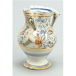 An Italian maiolica ewer, painted in shades of ochre, blue, green and manganese with with an oval...