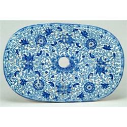 A Tendril pattern oval drainer, with decoratively shaped drainer holes, printed in blue with the...