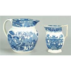 Two blue-printed jugs with chinoiserie patterns: a large jug of Dutch shape with strap handle and...