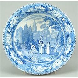 A blue-printed washbowl, decorated with a rural scene of gleaners with a prominent church spire i...