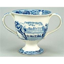 A blue-printed loving cup, decorated with a country house scene featuring two women and a child w...