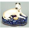 Image 1 : A porcelaineous penholder of a recumbent hound, probably a Great Dane, painted in pale-yellow ena...