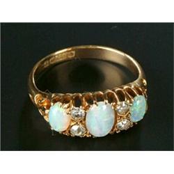 An Edwardian 18ct gold, opal and diamond dress ring, the three graduated oval white opals spaced...