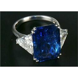 A sapphire and diamond three stone ring, centred with a rectangular step-cut sapphire weighing 13...