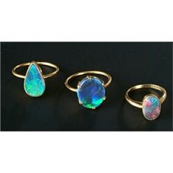 Three black opal single stone rings, comprising; an Edwardian gold and oval millegrain set ring d...