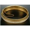 Image 1 : A Victorian gold and half-pearl bangle, the front with a central row of half-pearls between beade...