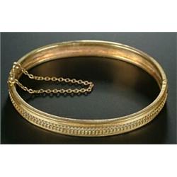 A Victorian gold bangle, the front with a central row of oval and beaded decoration, (see illus...
