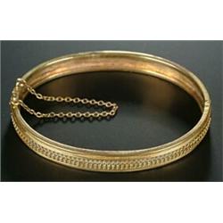 A Victorian gold bangle, the front with a central row of oval and beaded decoration, (see illus...