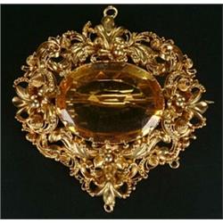 A 19th century gold and citrine cannetille brooch, the shaped-oval panel centred with an oval mix...