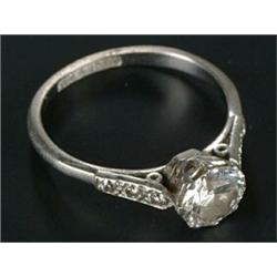 A diamond solitaire ring, the round brilliant approx. 0.97cts, claw set between small three stone...