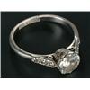 Image 1 : A diamond solitaire ring, the round brilliant approx. 0.97cts, claw set between small three stone...
