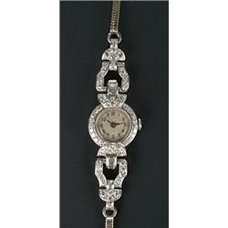 A lady's Swiss platinum and diamond round wristwatch, circa 1935, silvered dial with black Arabic...