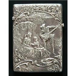 A late Victorian embossed silver card case, the front depicting a minstrel serenading two ladies...