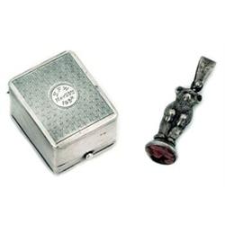 A silver ring box and a teddy bear seal, the rectangular ring box with and engine turned hinged c...