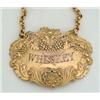 Image 1 : A George IV silver gilt decanter label 'Whiskey', stamped with fruiting vines, shells and acanthu...