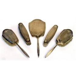 An early 20th Century 9 carat gold backed five piece dressing table set, engine turned and foliat...