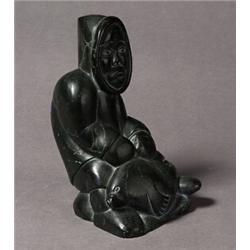 unidentified, Black stone carving of a man with fish, signed in syllabics to the underside and dat..