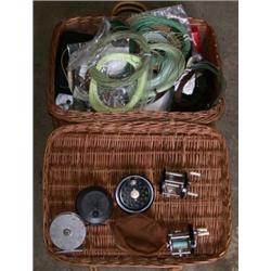 A wicker basket containing fly lines, reels and other items of fishing tackle...