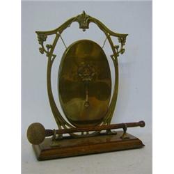 AN EDWARDIAN BRASS DINNER GONG, arched frame, with striker, height 29cm  30-40...