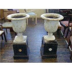 A PAIR OF CAST IRON OUTDOOR CAMPANA URNS, on square pedestals, 19th Century, acanthus leaf decora...