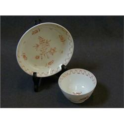 A GEORGIAN TEA BOWL AND SAUCER, painted floral design in puce £20-30...