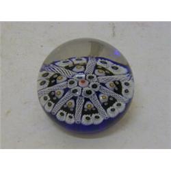 A MILLEFIORE GLASS PAPERWEIGHT, pink and blue daisies on indigo ground, height 3cm, diameter 6cm ...