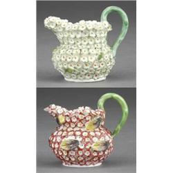 Two miniature compressed circular jugs, - Two miniature compressed circular jugs, encrusted with...