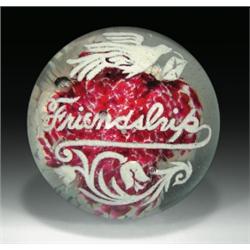 Antique American motto frit paperweight, with the word "Friendship" in white script, framed by a...