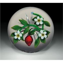 Delmo Tarsitano strawberry paperweight, containing a red strawberry, on a bright green vine with...