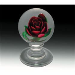 Charles Kaziun, Jr. crimp rose pedestal paperweight, with a tilted, crimson-red crimp rose, havin...
