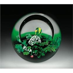 Caithness Glass "Island Dream" spherical paperweight, with a nature study of assorted deep green...