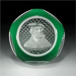Baccarat 1955 Martin Luther sulphide faceted paperweight, with a white cameo in a green-and-white...