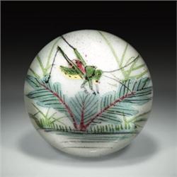 Chinese painted grasshopper paperweight, with a green, yellow, and pink insect, poised on a leafy...