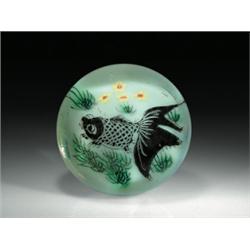 Chinese painted fish paperweight, having a black fish with large tail fins, swimming among water...