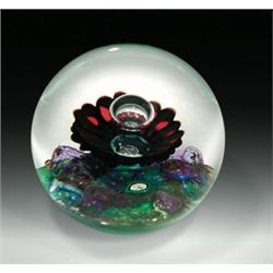 Selkirk Glass "Corona" abstract design paperweight, with a central bubble over a dark red flower...