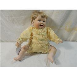 SMALL SEATED PORCELAIN DOLL